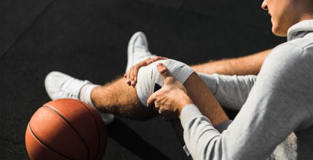 basketball player applying bandage knee